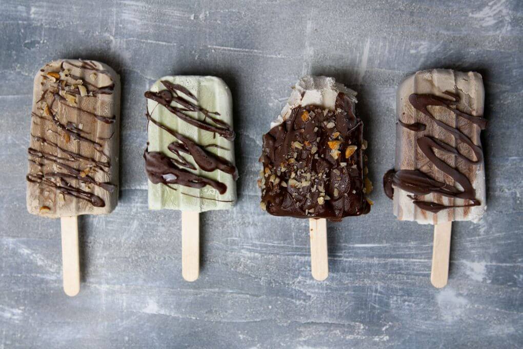 vier Sorten veganes Eis am Stil: Vanille, Schoko, Mokka und Minze